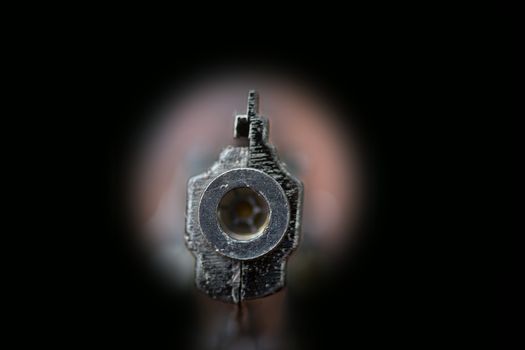 gun in keyhole isolated on black background