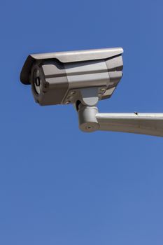 CCTV security camera, blue sky background.