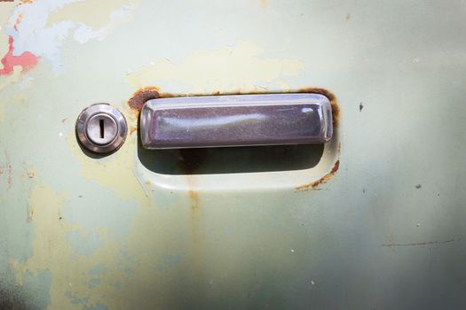 old rusty car door with keyhold.