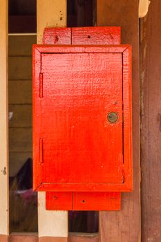red wooden postbox on the wall.