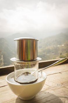 Coffee dripping in retro mood vietnamese style on wooden table.