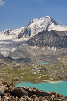 Scenic turquoise lake below highest peaks of Tien-Shan mountains in Kyrgyzstan