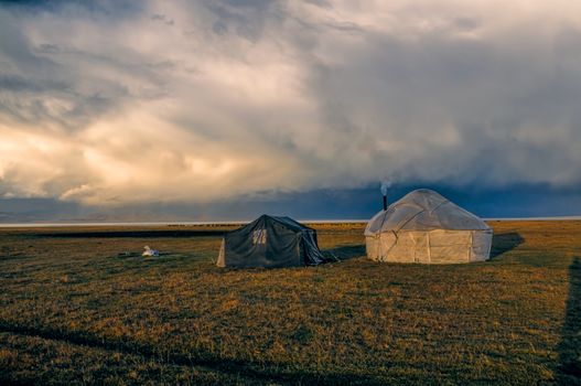 Scenic view of traditional yurt of nomadic tribe on green grasslands in Kyrgyzstan