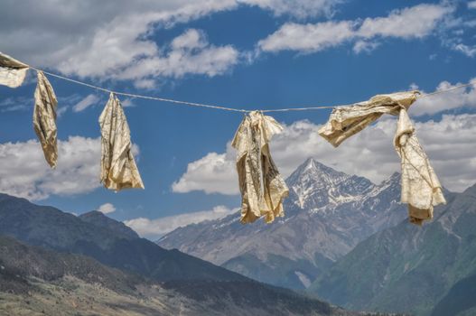 Buddhist prayer flags in Nepal with picturesque himalayan peak in the background