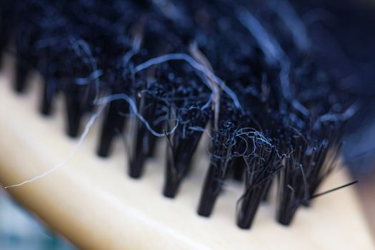 Close-up of a brush with lost hair on it, with shallow depth of field.