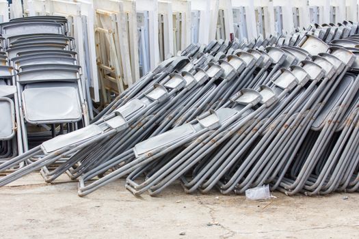Rows of empty folding chairs outdoors