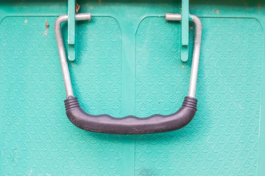 old black handle of green bucket, closeup.