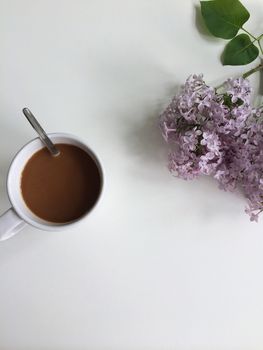 Morning coffee with milk and fresh lilac flowers