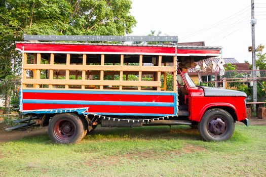 red vintage truck in side view on the green ground
