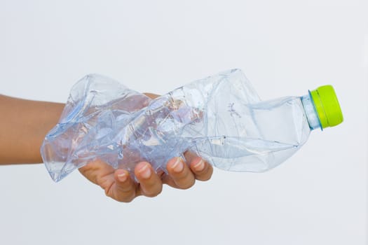 Hand holding used plastic bottle isolated on white background.