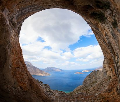 View of sea and islands from cave in mountain, focus on rock