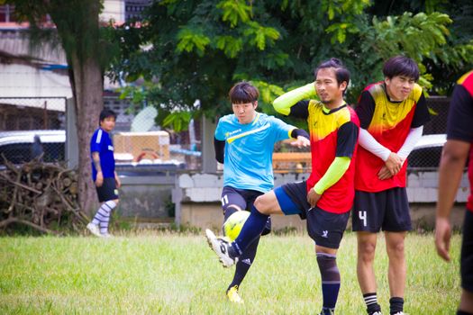 CHIANGRAI, THAILAND - AUG 9: unidentified male teenagers playing soccer in field on August 9, 2014 in Chiangrai, Thailand. Thai teenagers like to exercise by playing sports.