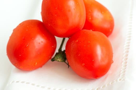 Tomatoes on white tablecloth close up