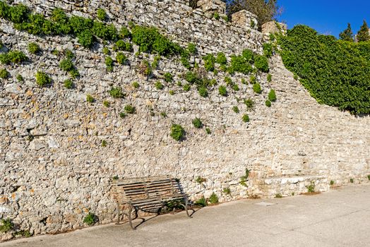 Bench against stone wall in Italy