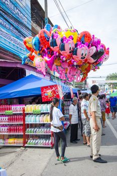CHIANGRAI, THAILAND - AUG 12: unidentified young woman selling comic colorful latex balloons at a market on August 12, 2014 in Chiangrai, Thailand.