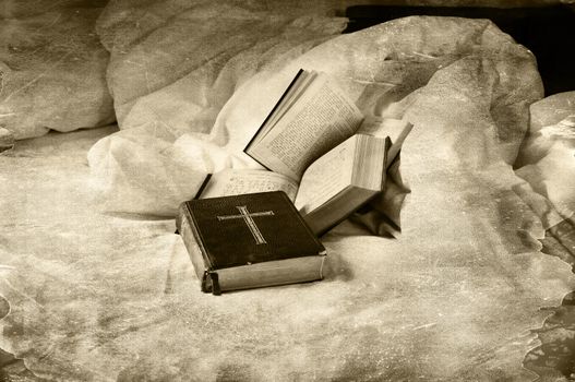 Religious books abandoned on a unmade bed grungy dark style.