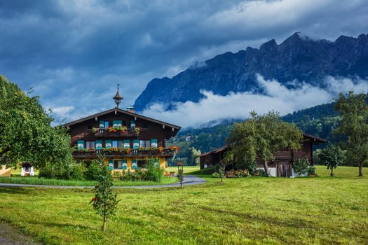 Summer landscape in Alps with traditional Austrian house. 