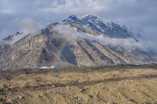 Rainbow forming above Engilchek glacier in Tian Shan mountain range in Kyrgyzstan