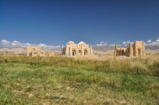 Ruins of ancient temple on green grasslands in Kyrgyzstan