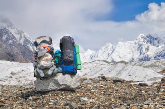 Two large backpacks on Engilchek glacier with scenic Tian Shan mountain range in Kyrgyzstan