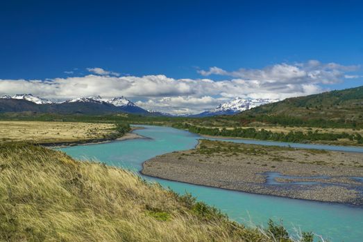 Amazing view of grassy plains   surrounding a river in Torres del Paine national park                 