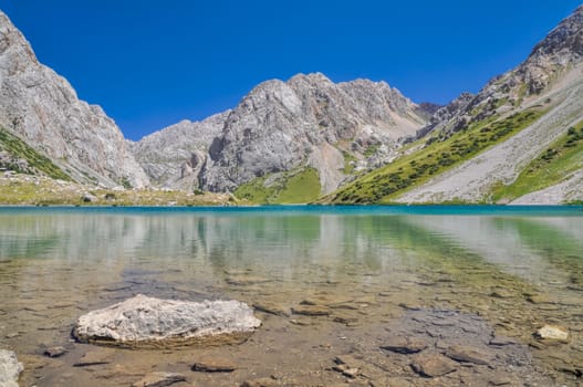 Crystal clear lake in mountain range Tien-Shan in Kyrgyzstan