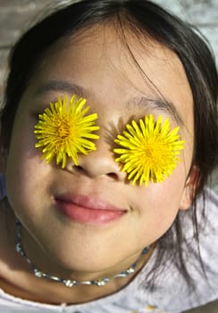Girl playing with yellow flowers