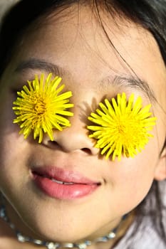 Girl playing with yellow flowers