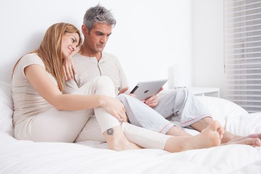 25-30, adult, apartment, attractive, bed, bedroom, caucasian, coffee, Couple, fun, handsome, happy, home, horizontal, house, leisure, lifestyle, love, marriage, men, model, nightwear, old, pc, people, person, property, releases, sitting, smile, tablet, tea, two, women, years, young
