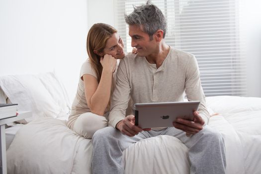 25-30, adult, apartment, attractive, bed, bedroom, caucasian, Couple, fun, handsome, happy, home, horizontal, house, leisure, lifestyle, love, marriage, men, model, nightwear, old, pc, people, person, property, releases, sitting, smile, tablet, two, women, years, young