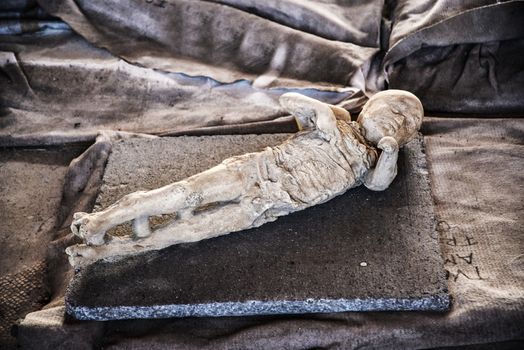 child's body inside the Roman archeologic ruins of the lost city of Pompeii,  Italy