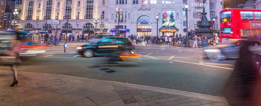 LONDON - SEPTEMBER 27 : Motion blurred traffic and people pass the Trocadero in Piccadilly Circus, London on September 27, 2013. The building was originally a restaurant and is now an entertainment hub