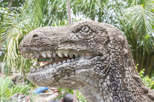head of dinosaur sculpture in public park.
