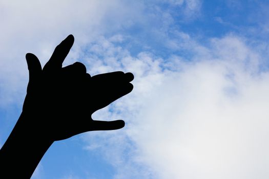 dog shape hand silhouette in blue sky and cloud, with copyspace