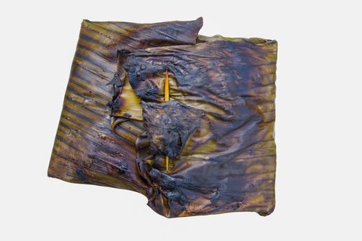 steamed fish with curry paste in banana leaves wrap (thai food) isolated on white background