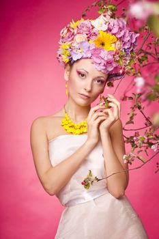 Young lady on a pink background with flower crown