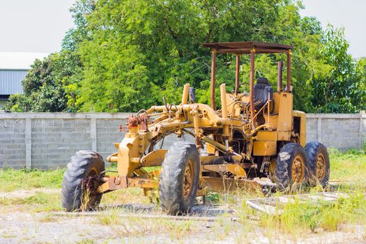 yellow abandoned  old road grader