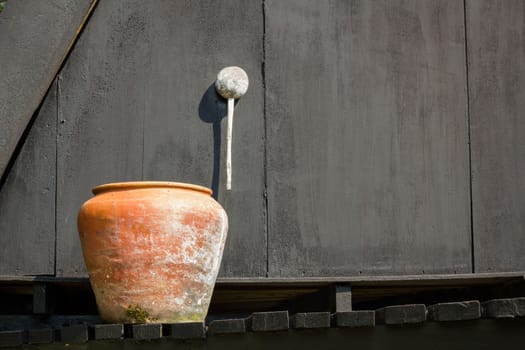 orange water jaron the black background of old wooden wall, with copyspace on the right