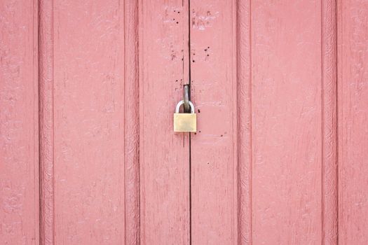 lock on the middle of pale red wood door, concept security