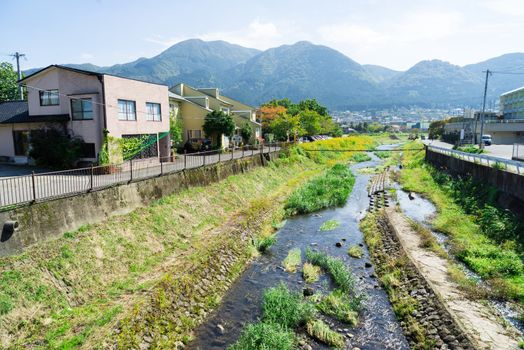 Yufuin, Japan - October 17, 2014: rural home village with mountain and canal landscape view