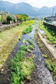 Yufuin, Japan - October 17, 2014: rural home village with mountain and canal landscape view