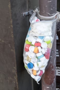 Yufuin, Japan - October 17, 2014: Locals take water bottle caps into the bag and hang them in front of the house for the purpose of recycling