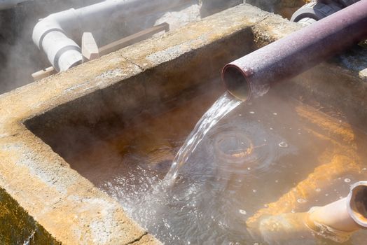 Hot water flowing out of pipe, hot spring water boiling, Beppu, Oita, Japan