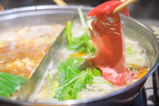 Raw beef getting down boiling in hot pot shabu