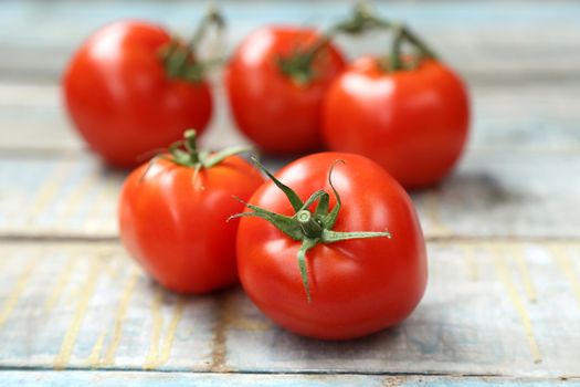 branch with fresh raw tomatoes on wooden background