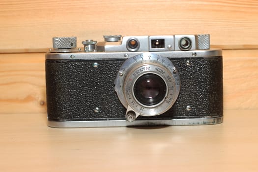 Vintage camera on a wooden background. Black, metal