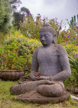 Peaceful Stone Garden Buddha Surrounded by Flowers