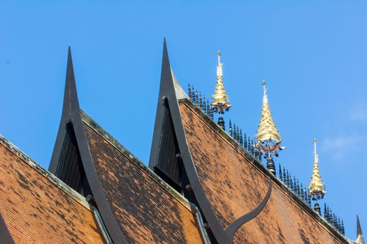 Thai art on roof Church at Thai temple in blue sky background