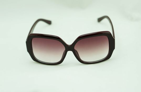 Brown sunglasses, edge glasses made of plastic placed on a white background.                              