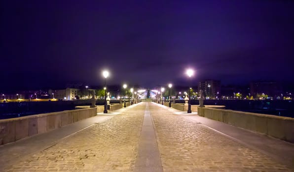 Madrid, Spain - May 8, 2012: Toledo Bridge over Manzanares River illuminated on a spring night, Madrid, Spain. It was built in XVII century.